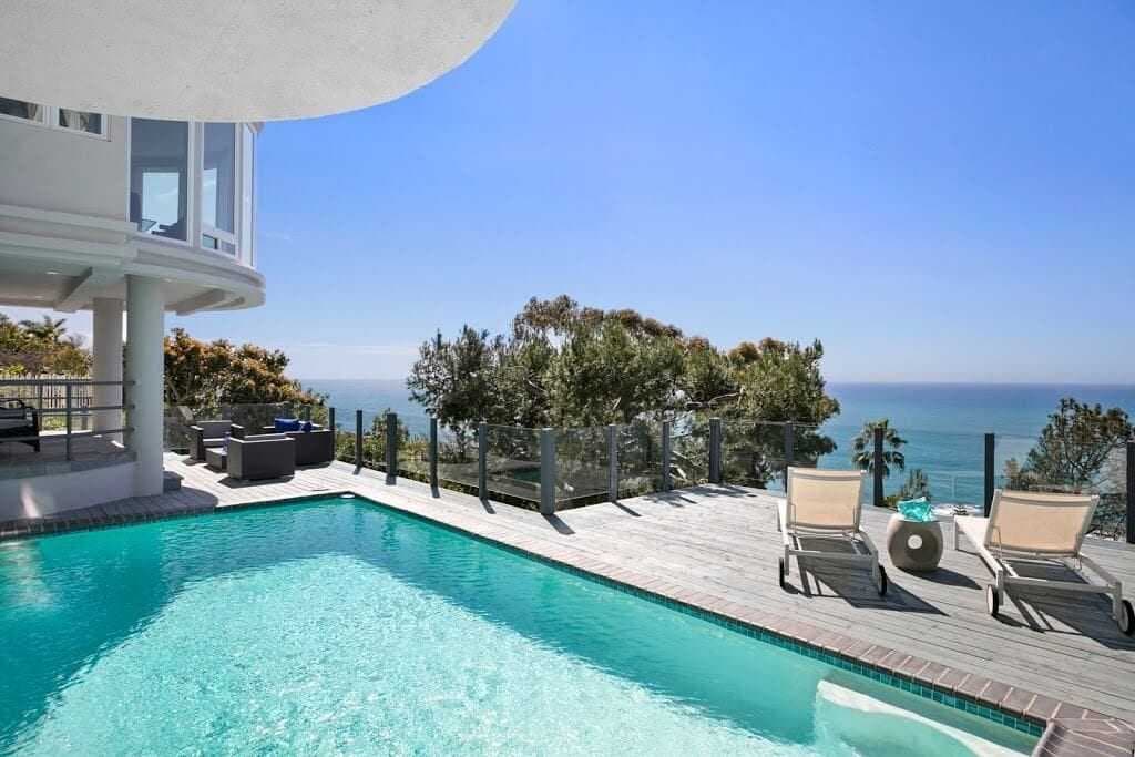 Outdoor pool and patio overlooking the coast